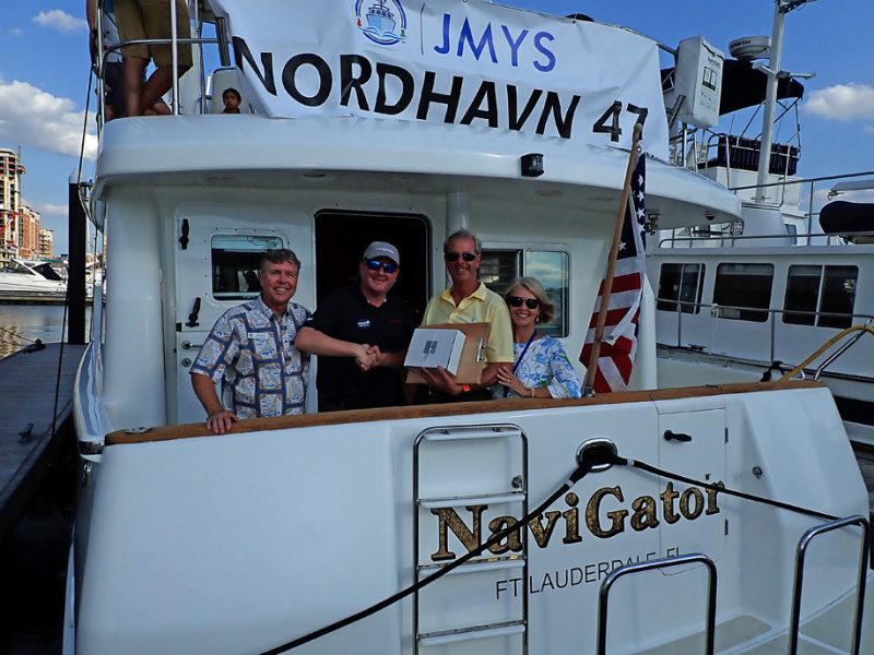 Picture of Jeff, Ryan, Mike and Patsy on boat being given award on Nordhavn 47